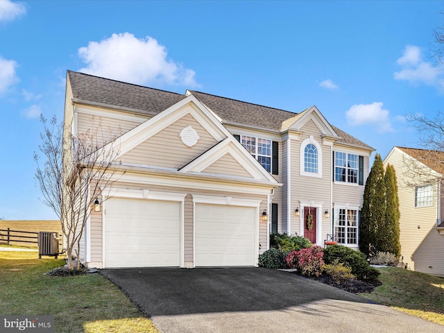 view of front of home with a garage and central air condition unit