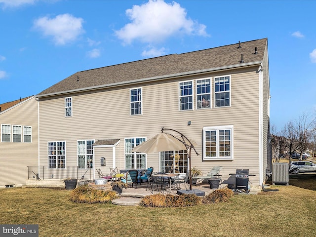 back of property with a lawn, central AC unit, and a patio area