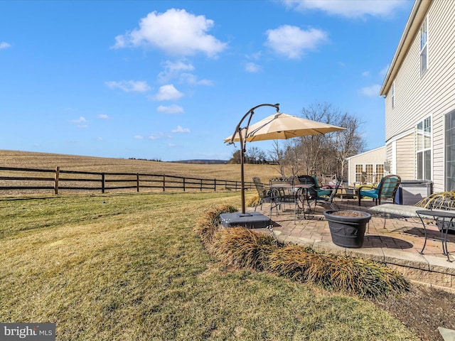 view of yard with a rural view and a patio area