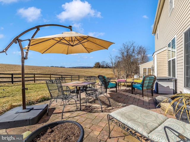 view of patio / terrace featuring a rural view and a hot tub