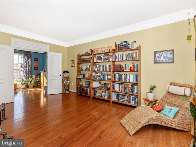 living area featuring crown molding and hardwood / wood-style floors