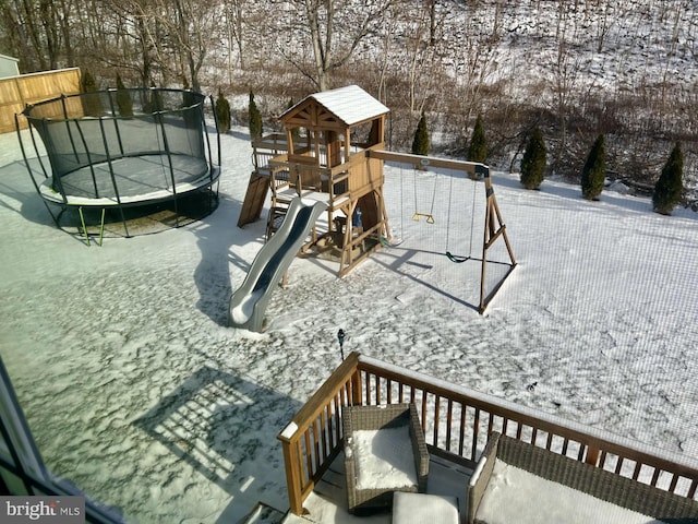 snow covered playground featuring a trampoline