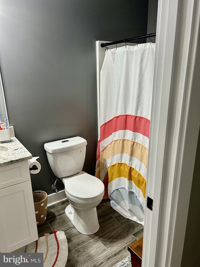 bathroom featuring vanity, hardwood / wood-style floors, and toilet