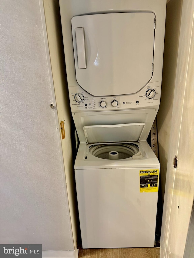 washroom featuring light wood-type flooring and stacked washer and clothes dryer