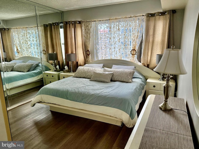 bedroom with a textured ceiling and hardwood / wood-style flooring