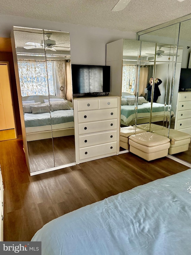 bedroom featuring a closet, dark hardwood / wood-style flooring, and a textured ceiling