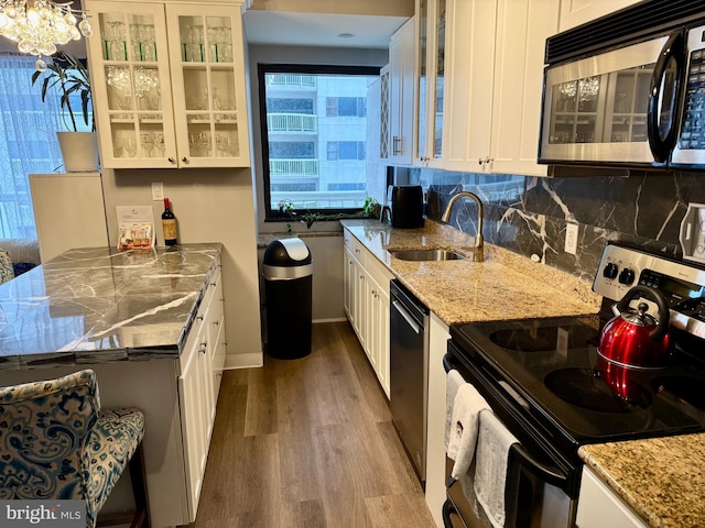 kitchen featuring white cabinets, backsplash, range with electric cooktop, and sink