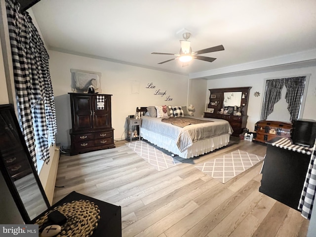 bedroom with light hardwood / wood-style flooring, ceiling fan, and ornamental molding