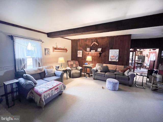 living room featuring beamed ceiling, wood walls, and carpet floors