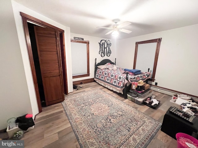 bedroom with light wood-type flooring, a closet, and ceiling fan