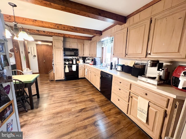 kitchen with sink, black appliances, beam ceiling, hardwood / wood-style floors, and hanging light fixtures