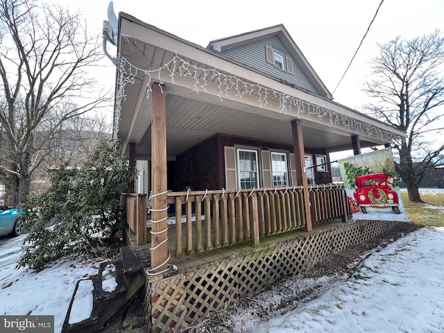 snow covered property featuring covered porch