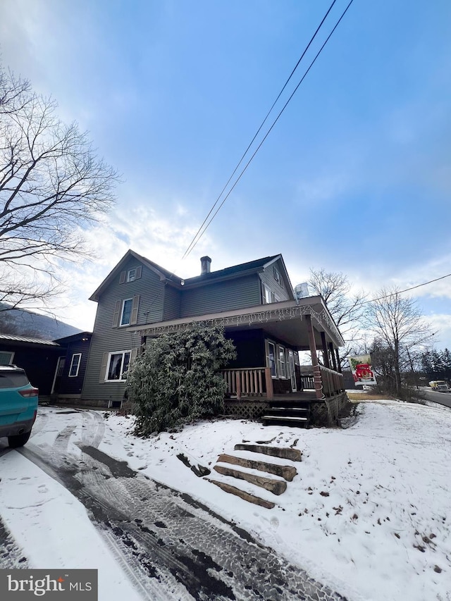 view of snowy exterior featuring a porch