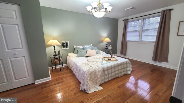 bedroom with an inviting chandelier and wood-type flooring