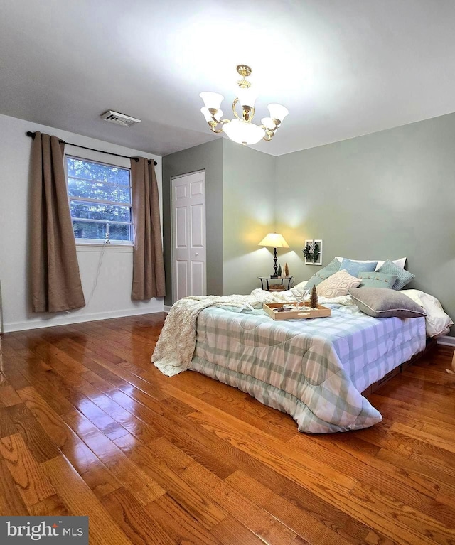 bedroom featuring an inviting chandelier and hardwood / wood-style floors