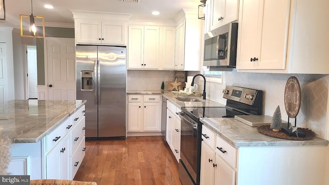 kitchen with light stone counters, stainless steel appliances, white cabinets, and pendant lighting