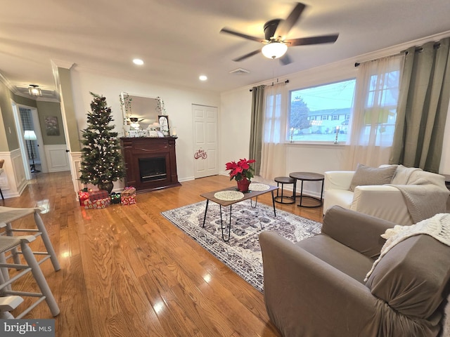 living room with ceiling fan, hardwood / wood-style floors, and ornamental molding