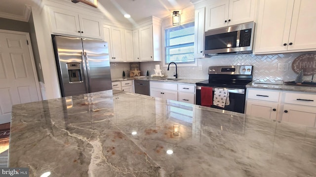 kitchen with white cabinets, stainless steel appliances, light stone countertops, sink, and tasteful backsplash