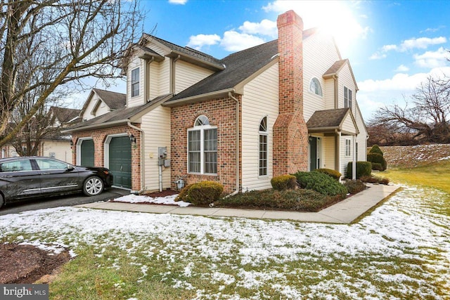 snow covered property with a garage