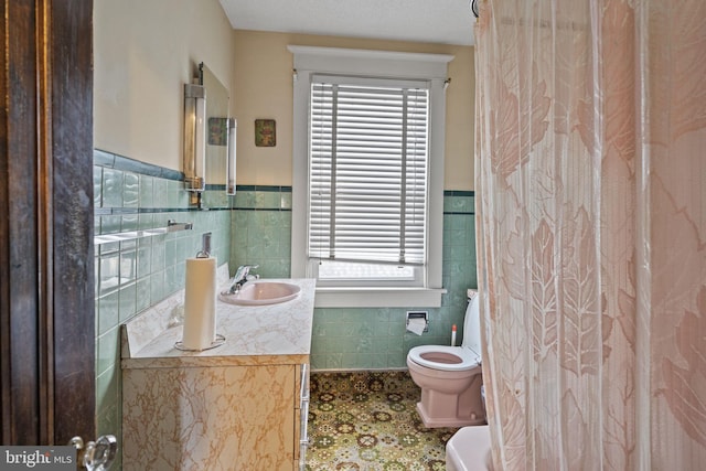 bathroom featuring vanity, toilet, and tile walls