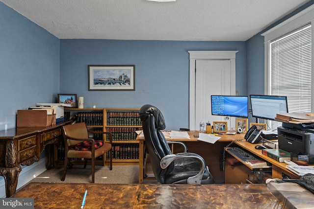 office area featuring a textured ceiling and dark carpet