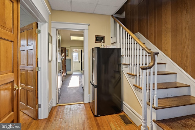 stairway featuring wood-type flooring and wooden walls