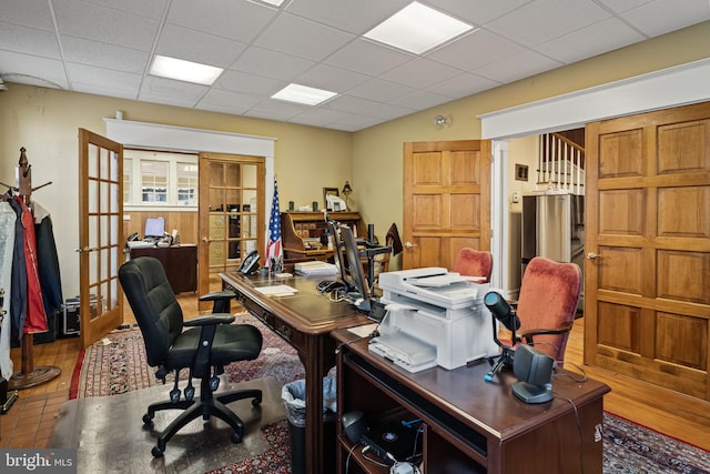 office with a drop ceiling and french doors