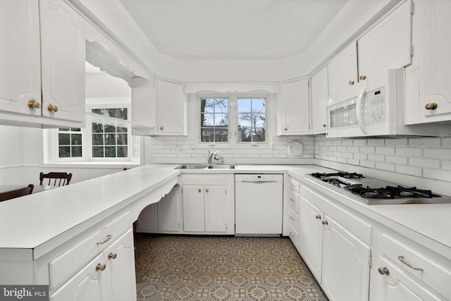 kitchen with white cabinetry, sink, white appliances, and decorative backsplash