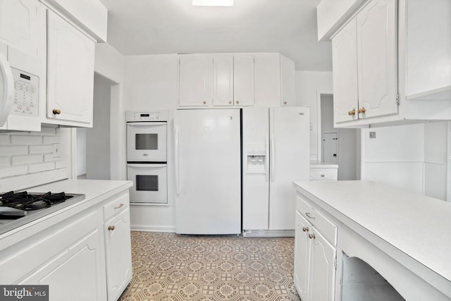 kitchen featuring white appliances, white cabinets, and tasteful backsplash