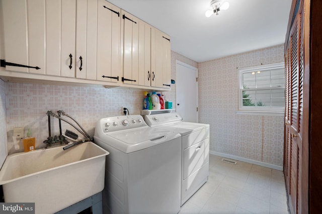 laundry room featuring cabinets, sink, and washer and clothes dryer