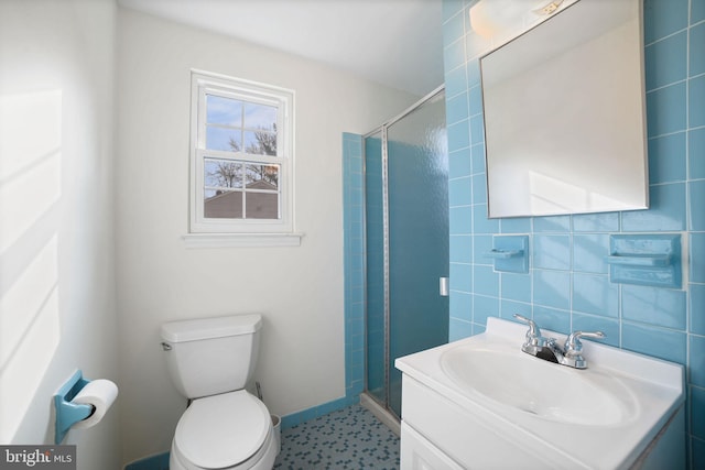 bathroom with a shower with shower door, toilet, and vanity