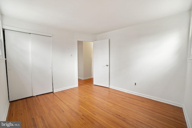 unfurnished bedroom with a closet and light wood-type flooring