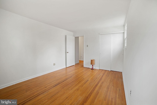 unfurnished bedroom with light hardwood / wood-style flooring and a closet