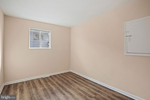 spare room with dark wood-type flooring and electric panel