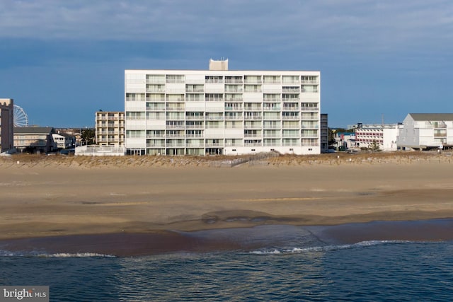 view of building exterior with a water view and a beach view