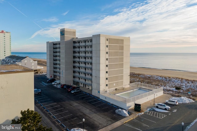 view of building exterior featuring a water view and a view of the beach