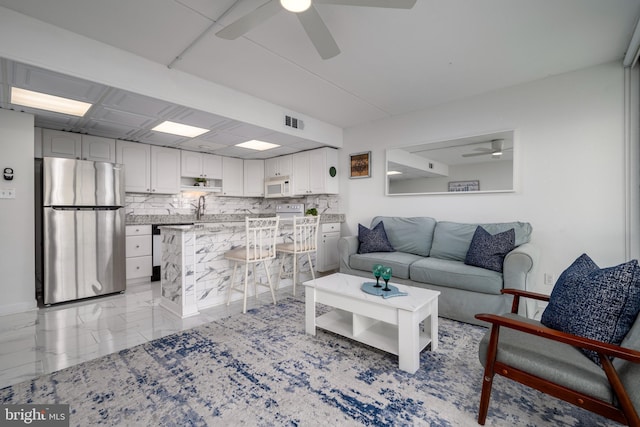 living room with ceiling fan and sink