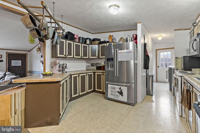 kitchen featuring a textured ceiling, kitchen peninsula, stainless steel appliances, and ornamental molding