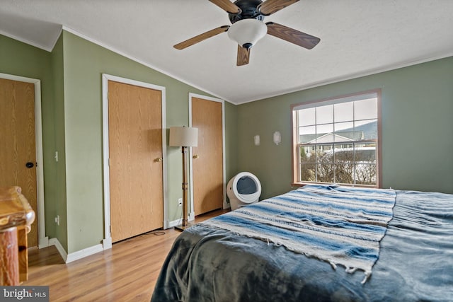 bedroom with ceiling fan, crown molding, a textured ceiling, vaulted ceiling, and hardwood / wood-style flooring