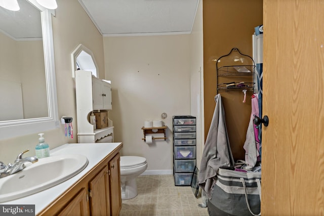 bathroom featuring vanity, toilet, and crown molding