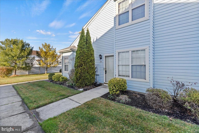 view of exterior entry with a lawn