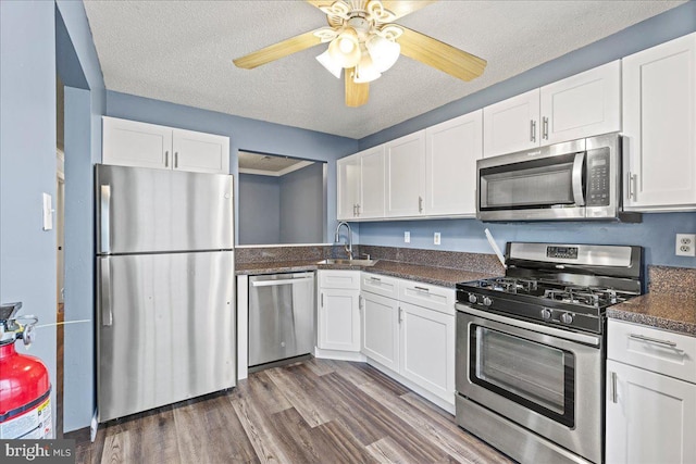 kitchen featuring a textured ceiling, stainless steel appliances, and white cabinetry