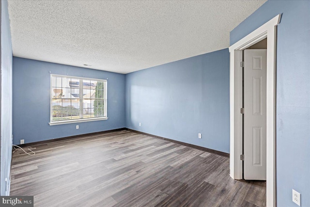 spare room featuring a textured ceiling and wood-type flooring