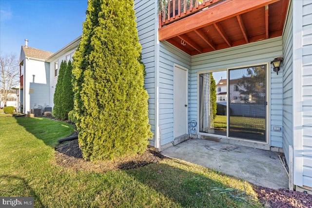 doorway to property with a patio, central air condition unit, and a yard