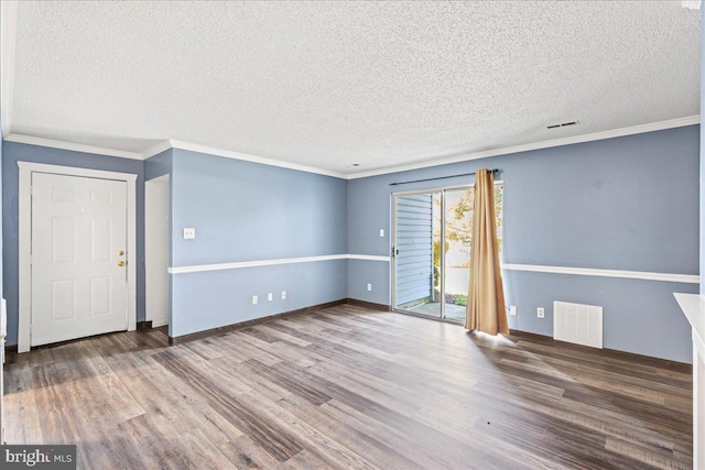 unfurnished room featuring a textured ceiling, crown molding, and wood-type flooring