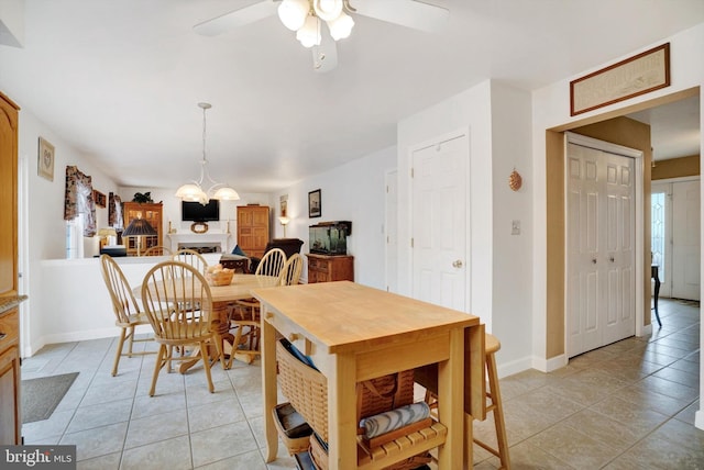 dining area with ceiling fan with notable chandelier and light tile patterned floors