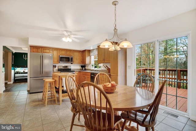 dining area with ceiling fan with notable chandelier, plenty of natural light, light tile patterned floors, and sink