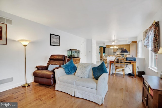 living room featuring light hardwood / wood-style floors and ceiling fan