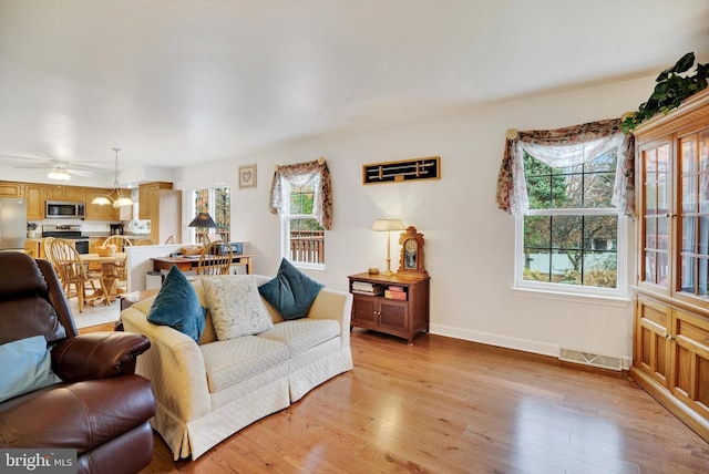 living room with ceiling fan and light wood-type flooring