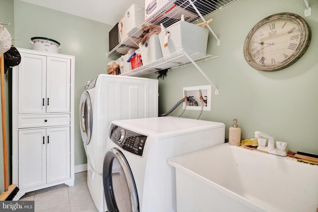 washroom featuring light tile patterned floors, cabinets, washer and clothes dryer, and sink